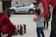Una donna aiuta a montare i birilli di tronco per i bambini