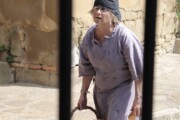 Un'abitante in costume da contadina regge un cesto di vimini