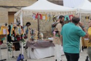 Un banco d'artigianato tessile attira i visitatori del mercato medievale