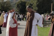 Una dama conversa con un frate durante il corteo per le vie