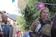 Un cavaliere con la spada sfila nella scorta armata del Graal