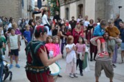 Un giullare suona il tamburello davanti alle famiglie in una via di Bailo
