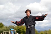 Un attore sui trampoli si esibisce con la sierra di Huesca sullo sfondo