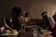 Le donne del paese distribuiscono panini durante il pranzo popolare