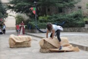 Una giovane salta sopra i fasci di paglia nella piazza di Bailo