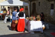 Due donne visitano un banco d'artigianato floreale al mercato