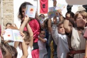 Alcuni bambini sollevano libretti sulla leggenda del Santo Graal
