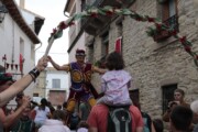 Un trampoliere tende il braccio sotto un arco di fiori a Bailo