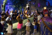 Un testone intrattiene bambini e adulti con un telo verde